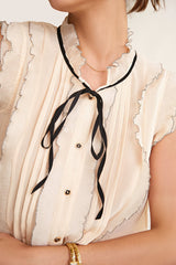 Ivory Sleeveless Ruffled Tie Neck Blouse